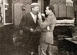 Black and white film still showing actors in period costume