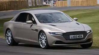 Front three-quarters view of a gold saloon on a race track