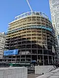 Uncladded shell of a building with 13 floors, with additional smaller floors being constructed above