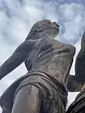 Adjacent to the central figure of the monument is a woman standing beside the man