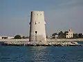 Al-Maqta' Tower (Arabic: بُرْج ٱلْمَقْطَع, romanized:&nbsp;Burj Al-Maqṭaʿ; front) and Al-Maqta' Fort (Arabic: حُصْن ٱلْمَقْطَع, romanized:&nbsp;Ḥuṣn Al-Maqṭaʿ; back), just outside the island of Abu Dhabi