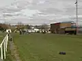 Cricket pitch end and cricket pavilion with changing rooms underneath.