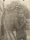 1938 photo of a young Assyrian in Arzni carrying grass