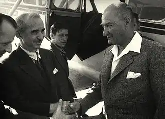 Atatürk and İnönü shaking hands near an aircraft