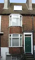 Brick coloured mathematical tiles on a bay window in George Street Location on Google Maps