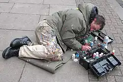 Man lying on pavement, painting chewing gum