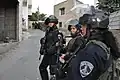 Border police officers in blue jumpsuit.
