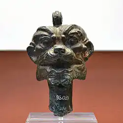 A bronze Pazuzu head, including a loop to be strung onto a necklace and worn as a protective charm.