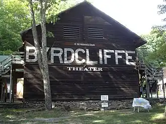 Wooden building with a stone base, and in big letters Byrdcliffe is painter across the entire side, with Theater in smaller letters below