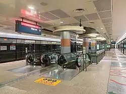 View of the CCL island platform, with a pair of escalators leading downwards from the platforms.