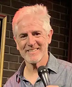 Alazraqui holding a microphone