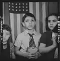 Children waiting in line to buy defense stamps at public school from mothers who volunteer to guard doorways and perform other duties in schools