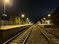 Southbound view of the station platforms at night, November 2023