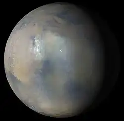 Multiple images from the MARCI were used to generate this view of a regional dust storm obscuring Syrtis Major and Jezero Crater (white circle). The images were acquired on Jan. 9, 2022.
