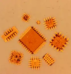 Figure 5. An array of beam leaded silicon integrated circuits showing the attached and extended electroformed beam leads around the perriphery of the silicon chip