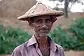 A farmer in Bangladesh wearing a mathal (মাথাল)