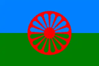 Flag of the Romani People. It contains blue and red colour to represent the heaven and earth respectively, and uses a 16 spoke Dharmachakra to symbolise their tradition and to pay homage to their Indian origin.
