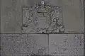 Stone-of-arms bearing an inscription.