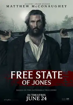 A bearded man holding a rifle across his shoulders