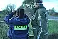 An SQ agent with a pre-2016 uniform observing the border with an RCMP officer