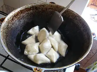 Kazakh boorsoq being fried in a stove-top kazan.