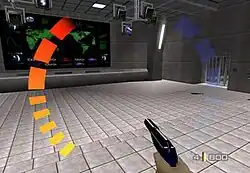 A room with a large monitor displaying a world map. A hand holding a gun is shown at the bottom. Around the image are graphic symbols representing the player's health, ammunition, and armour levels.