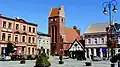 Main church and an 18th-century timber frame tavern on the marketplace in Golub