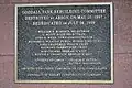 A plaque, located within the grandstand, that commemorates the park's rebuilding after it was destroyed by an arsonist.