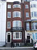Terracotta coloured mathematical tiles on a bay window in Grand Parade Location on Google Maps