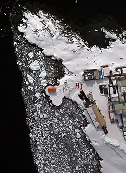 Residents use their red parkas to send a greeting to NASA's DC-8.