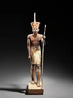 A guardian statue which reflects the facial features of the reigning king, probably Amenemhat I or Senwosret I, and which functioned as a divine guardian for the imiut. Made of cedar wood and plaster c. 1919–1885 BC[80]