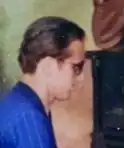 Colour profile snap of jazz pianist of the Hot Club Combo, wearing sunglasses (shades) and the band's uniform blue suit. He has short, 1940s- style, swept-back hair.
