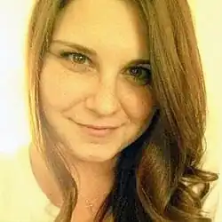 Caucasian woman in her early 30's, with long, straight brown hair, smiling at the camera.