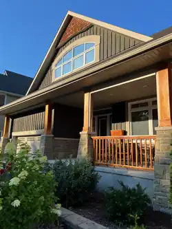 a) Board-and-Batten siding, b) Square-post ornamentation, c) Shingle-style, gable apex ornamentation, d) Front verandah (built, 2006)