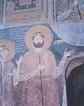 Medieval mural portrait on the interior walls of a church depicting a tall bearded man in a noble's attire
