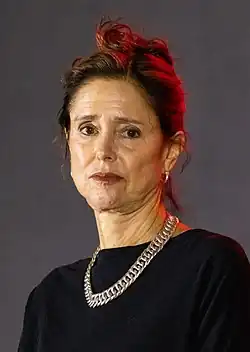 Headshot of Caucasian woman with brown hair wearing black with silver necklace
