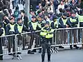 PTU officers stand guard behind a barricade.