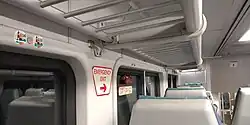 Interior of the upper level of a C3 car with Hamptons Reserve stickers and seat numbers visible, forming part of a different consist