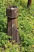 Small metal bollard adorned with stylized waves.