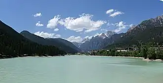 A body of water with trees and mountains in the distance.