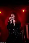 A woman sings into the microphone.