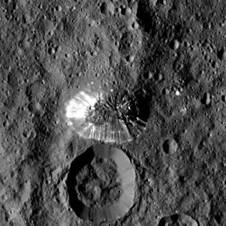 A smooth-sided mountain rising from a grey surface