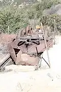 Three 1,600 pound motorized drive wheels and motor armature with a snow plow mounted on rails over the service pit. Recovered in 1993 from the downhill side of Echo Mountain.