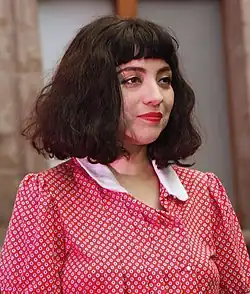 Close up image of Mon Laferte facing right