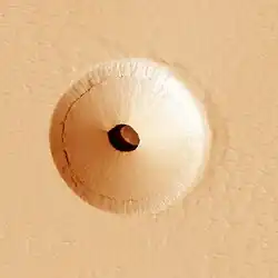 HiRISE image (color) of a 35 m wide lava tube skylight surrounded by a collapse pit on Pavonis Mons