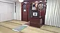Inside the prayer hall of the mosque with the wooden mihrab and minbar.