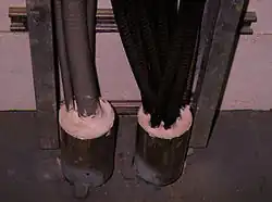 Electrical cable through-penetration, fire-stopped by an intumescent sealant, to restore the two-hour fire-resistance rating of the concrete floor.