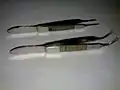 Upper one: Suture tying forceps; Lower one: Iris forceps; For comparison