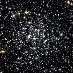 Several hundred stars of different brightnesses and colours scattered on a black background