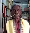 Haldhar Nag in 2022, with the interior of Haldhar Kutir in the background.